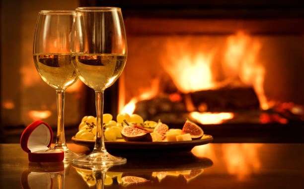 istock Two wine wineglasses with the red box with engagement ring over fireplace background. 852593908