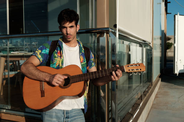 istock Young man playing guitar close to restaurant 852617432