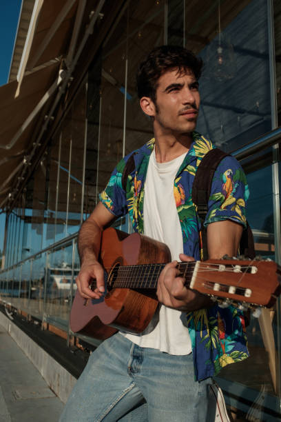 istock Young man playing guitar close to restaurant 852617528