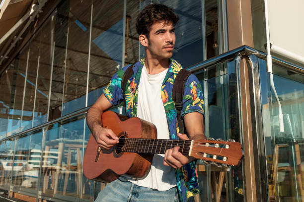 istock Young man playing guitar close to restaurant 852617534