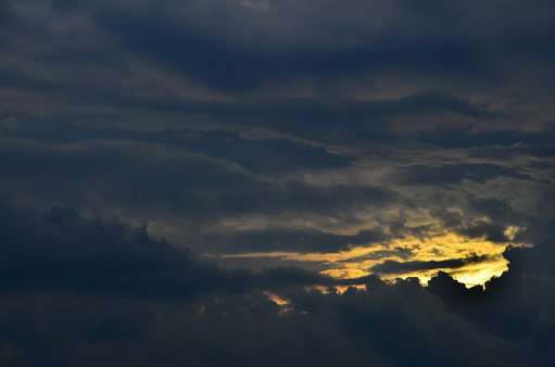 cloudy cover of the dark sky and the light of sunset.