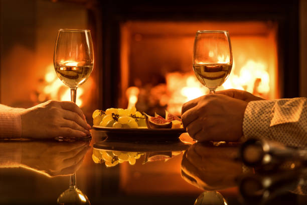 istock Young couple have romantic dinner with wine over fireplace background. 852635326