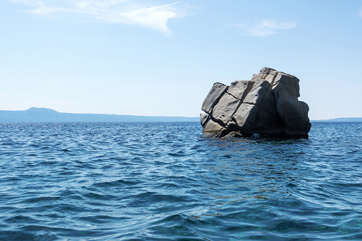 Rock islet on sea in Ouranoupoli, Greece.