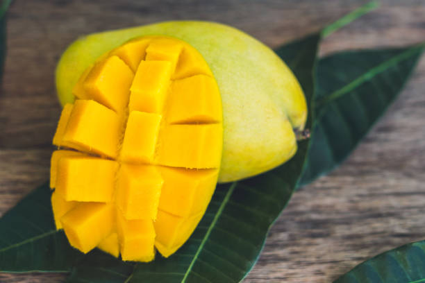 istock Mango and mango leaves on an old wooden background 852647428