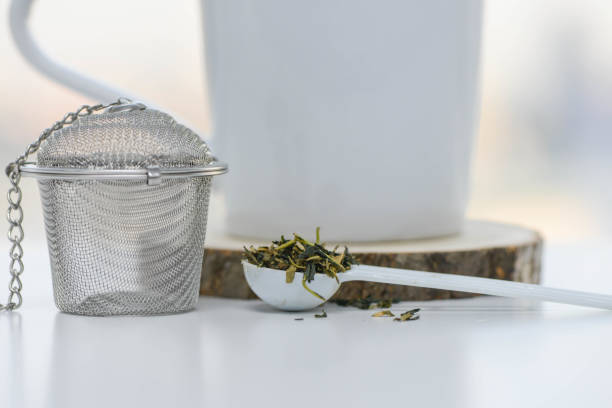 High angle view of a cup of hot organic black tea and a container of dried black tea leaves on kitchen counter.  High resolution 42Mp studio digital capture taken with Sony A7rII and Canon EF 70-200mm f/2.8L IS II USM Telephoto Zoom Lens