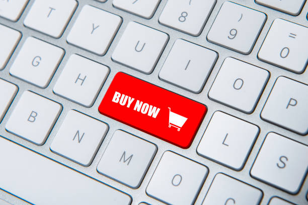 High angle view of red colored buy now button on computer keyboard. Horizontal composition. Image taken with Nikon D800 and developed from Raw format. Studio shot.