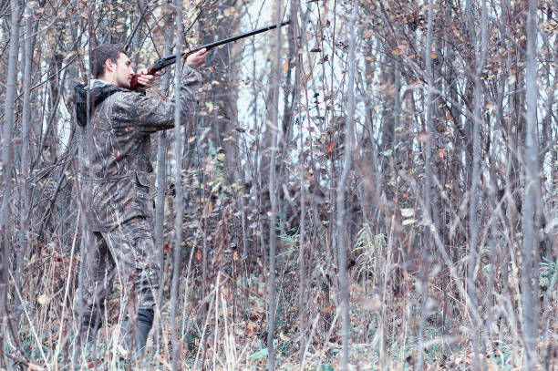 istock A man in camouflage and with a hunting rifle in a forest on a sp 852677856