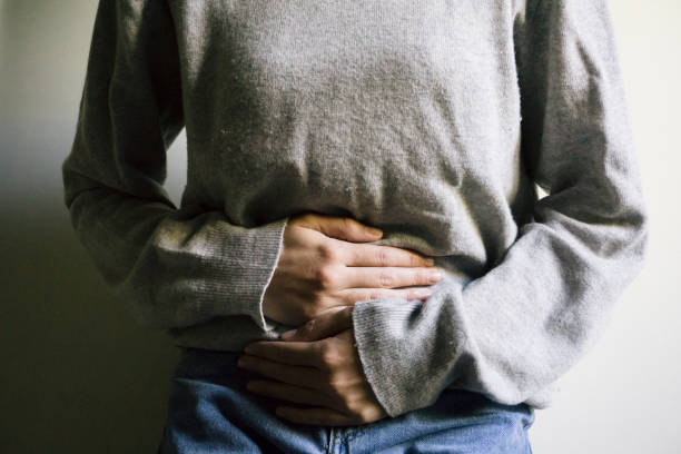 inflammation de la douleur - holding belly photos et images de collection