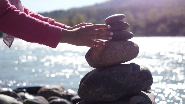 istock Female hands putting pebble stack next to the mountain river on sunny day 852701484