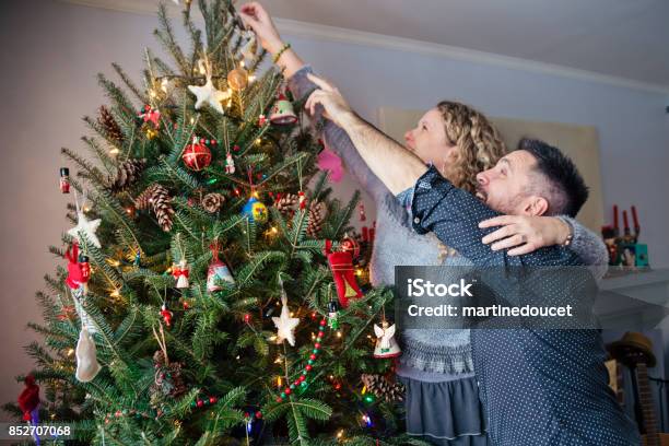 Älteres Paar Dekorieren Weihnachtsbaum Zu Hause Stockfoto und mehr Bilder von Dekorieren - Dekorieren, Paar - Partnerschaft, Tannenarten