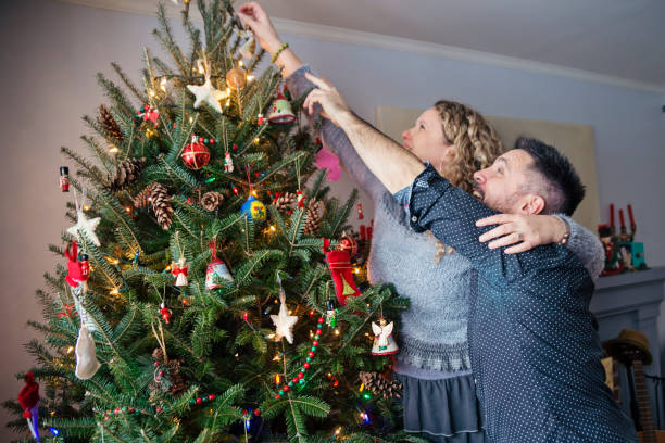 istock Mature couple decorating Christmas tree at home. 852707068