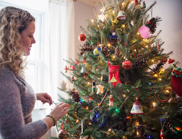 istock Mature woman decorating Christmas tree at home. 852707206