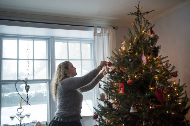 istock Mature woman decorating Christmas tree at home. 852707712