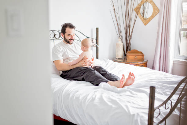 istock Young happy father playing with babyon bed 852740132