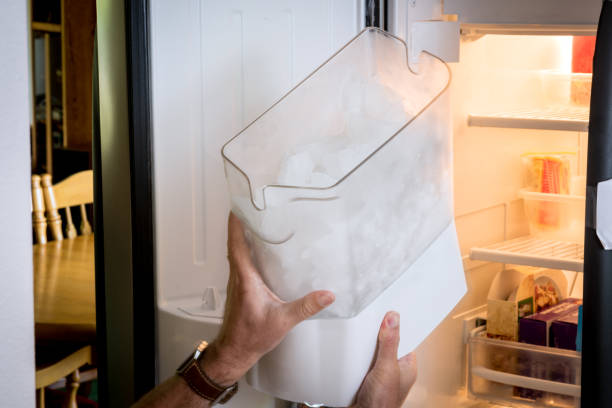 Man demonstrates how to remove an ice cube maker Icemaker remove shown with human hands ice maker stock pictures, royalty-free photos & images
