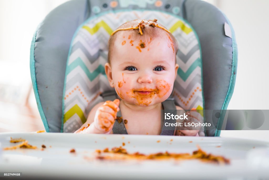 Little baby eating her dinner and making a mess A Little baby eating her dinner and making a mess Baby - Human Age Stock Photo