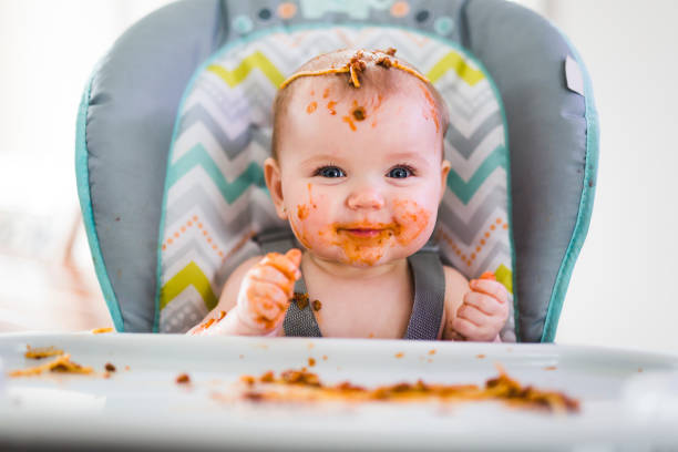 bebê comendo o jantar e fazer uma bagunça - high chair - fotografias e filmes do acervo