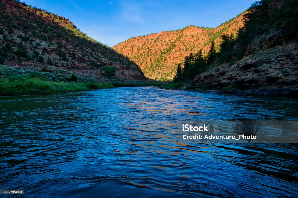 Colorado River Canyon Reflections at Sunset Colorado River Canyon Reflections at Sunset - Warm and cool tones reflecting in blue water. Autumn Stock Photo