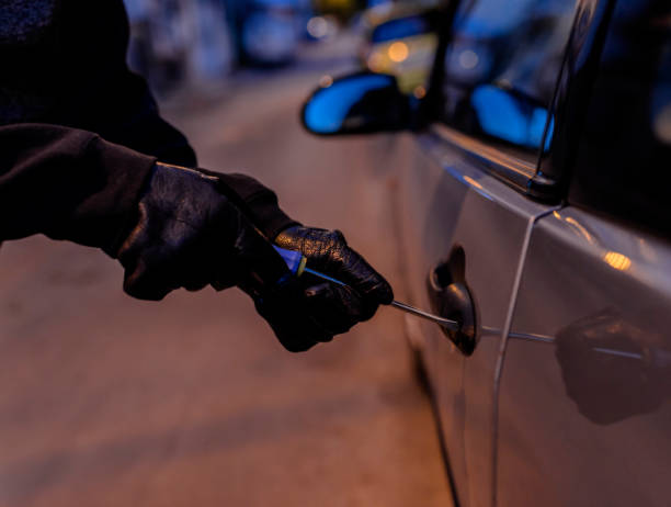 istock Car Thief Using a Screwdriver to Brake into a Car 852775648