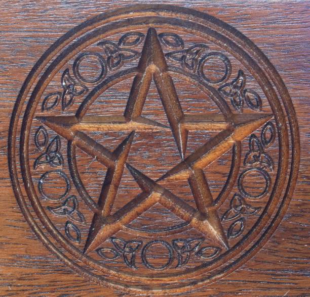 istock Pentacle with patterned surround carved in a dark wooden block 852792176