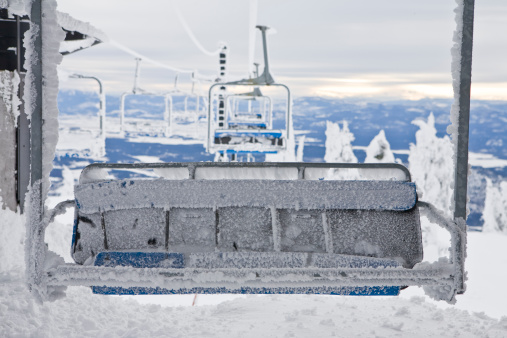 A frozen chairlift at the Whitefish Mountain Resort with the Flathead Valley in the background.