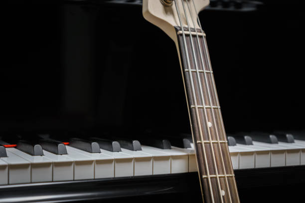 istock bass guitar against grand piano keys 852808792