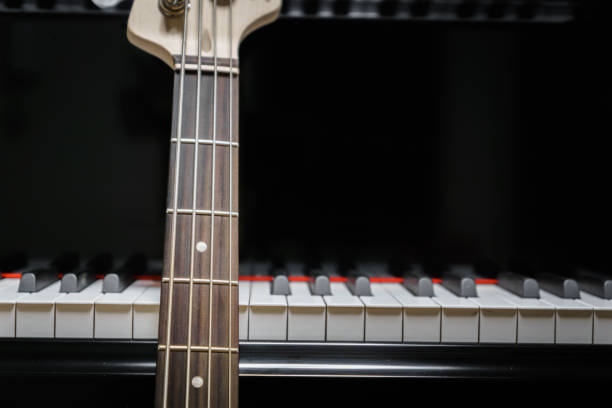 istock bass guitar against grand piano keys 852809044
