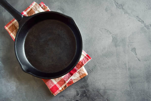 Cast iron pan on black background Cast iron pan on rustic grey concrete background close up -  empty black frying pan frying skillet with copy space skillet stock pictures, royalty-free photos & images