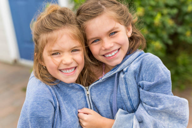 happy sisters on the beach with the same hoodies