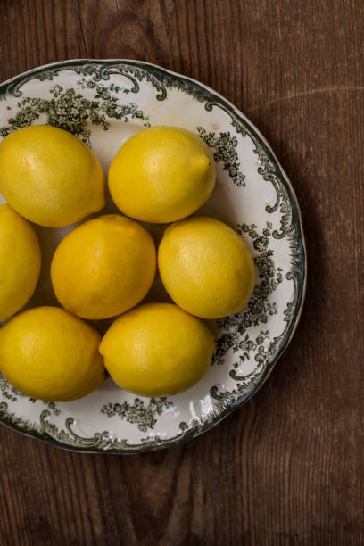 istock Lemons on white plate with green ornament 852858890