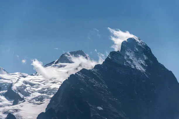 Closeup of Eiger in clouds, a peak in the Swiss Alps in Europe, with a part of Aletschglacier visible