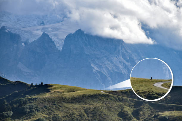 een ballon ingezoomd-in van een kleine wandelaar in tegenstelling tot de enorme gebergte op de achtergrond, creëren een gevoel van nederigheid en schaal - inzoomen stockfoto's en -beelden