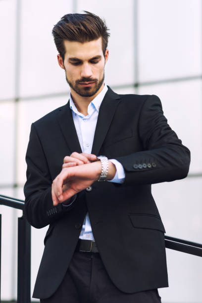 istock Young elegant businessman looking at his watch 852918502
