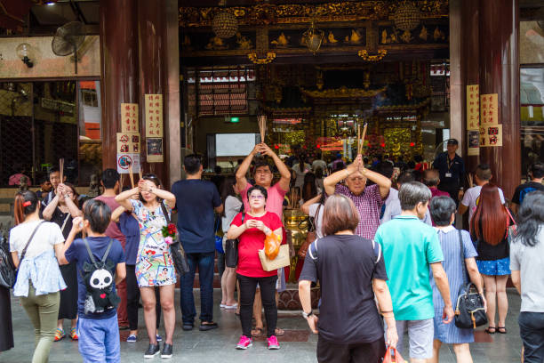 Historical Chinese Temple in Singapore Worshippers flock to the historical Kwan Im Thong Hood Cho Temple to pray during the Hungry Ghost Festival. Since 1884, this Chinese Goddess of Mercy temple has attracted devotees to worship from around the world. kannon bosatsu stock pictures, royalty-free photos & images