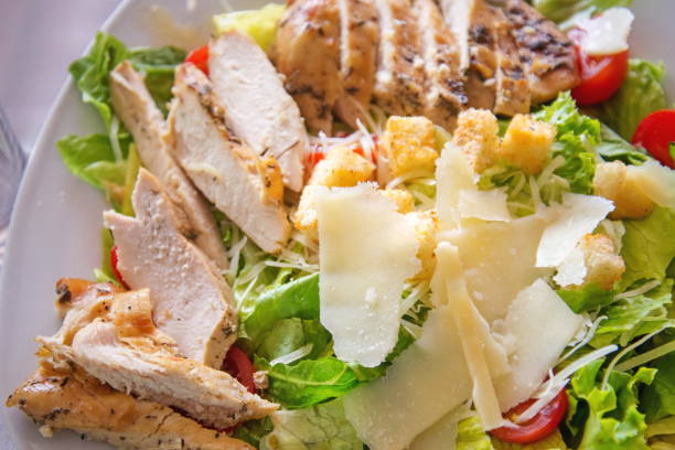 istock Caesar salad with chicken, selection of cheese, and cherry tomatoes. Top view 852939504