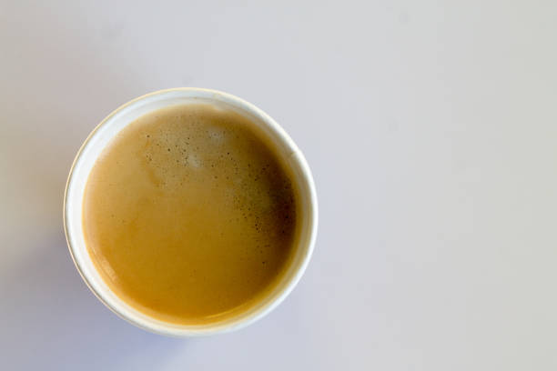 istock Coffee to go with foam in a paper cup on a white background 852945384