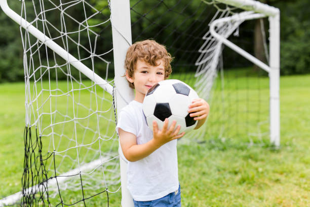 istock Young Boy with football on a field having fun 852949072