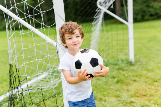 istock Young Boy with football on a field having fun 852949148