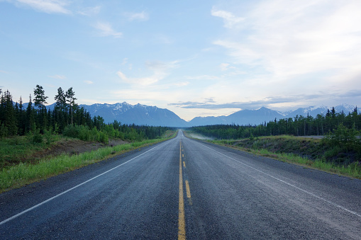 Shot from the centre of a long straight deserted stretch of Alaska Highway in Kluane National Park, Yukon Territory, Canada.