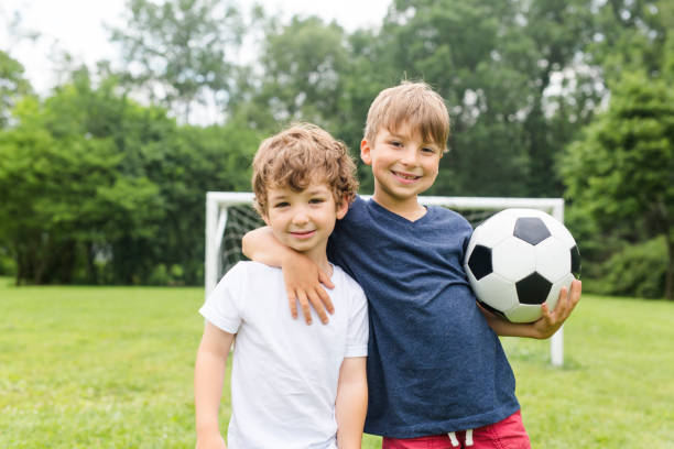 due fratelli che si divertono a giocare con la palla - ball horizontal outdoors childhood foto e immagini stock