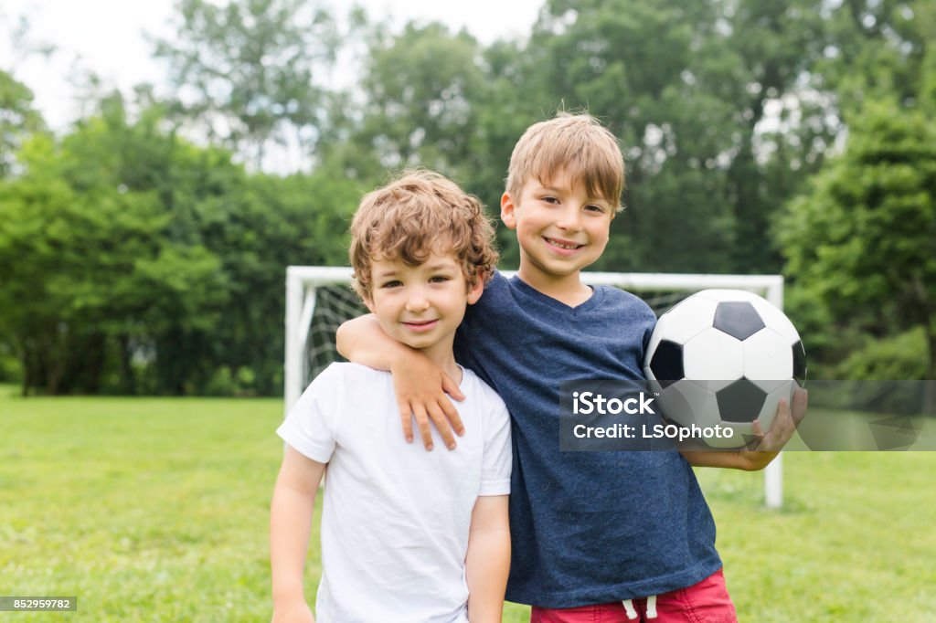 Two brothers having fun playing with ball Two little brothers having fun playing with ball Child Stock Photo