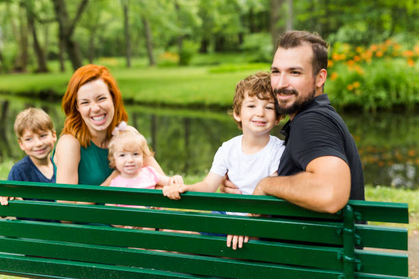 istock Happy family sitting on bench in park 852960666