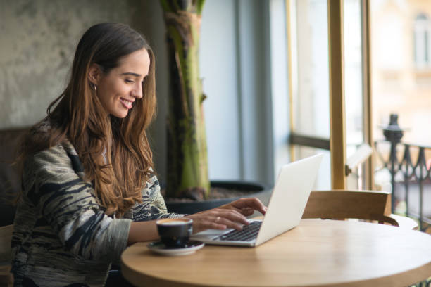 istock Beautiful woman using laptop at the bar 852997326