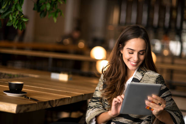 istock Smiling woman using digital tablet at the bar 852999744