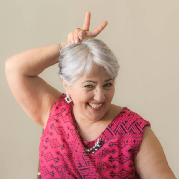 istock Mature woman doing finger horns 853012100