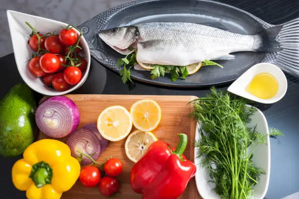 Raw uncooked sea bass with  lemon, olive oil, herbs and spices