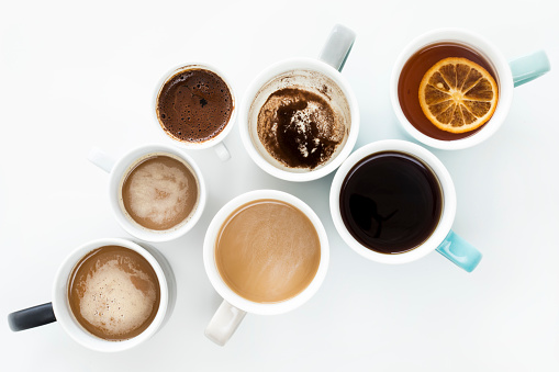 Different cups of coffee on white background