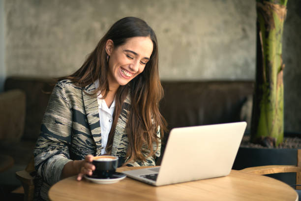 istock Smiling woman using laptop at the bar 853079526
