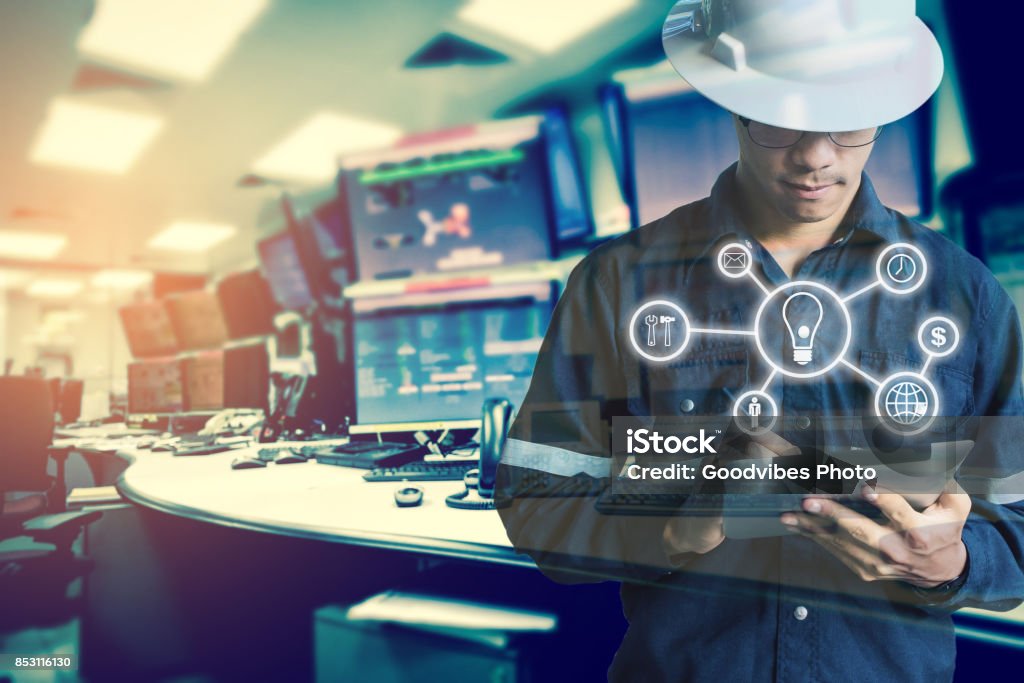 Double exposure of Engineer or Technician man with business industrial tool icons while using tablet with monitor of computers room  for oil and gas industrial business concept. Order Stock Photo