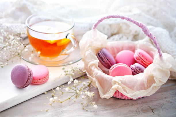 istock Tea with lemon, wild flowers and macaron on white wooden table 853124534
